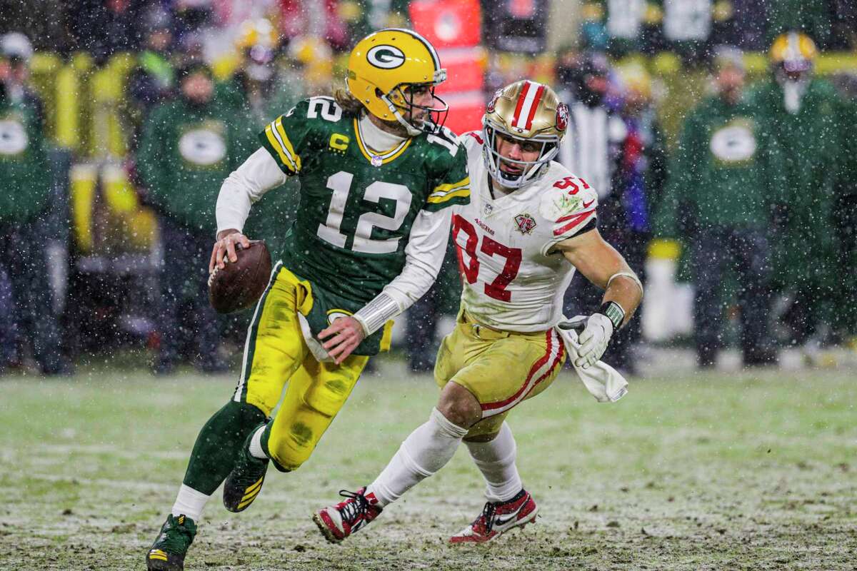 Green Bay Packers quarterback Aaron Rodgers (12) drops back to pass as snow falls as the San Francisco 49ers play the Green Bay Packers in the NFL Divisional Round playoff game at Lambeau Field in Green Bay, Wis., on Saturday, January 22, 2022.