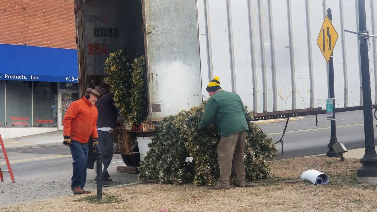 Members of the Alton Godfrey Rotary pack up parts of the Christmas tree into the trailer until next year. 