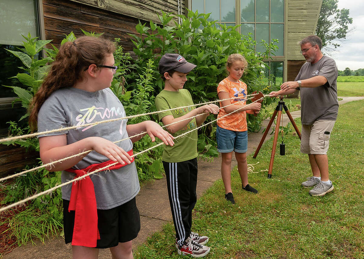 Lewis and Clark Community College adjunct instructor and superintendent at the Lewis and Clark State Historic Site in Hartford Brad Winn, far right, shows College for Kids students how rope was made in the era of frontier exploration.