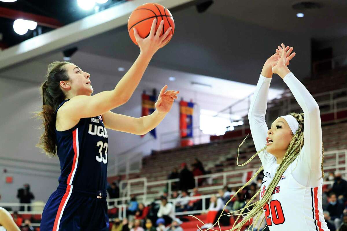 UConn’s Caroline Ducharme, left, drives to the basket against St. John’s Rayven Peeples during the second half Sunday in New York.