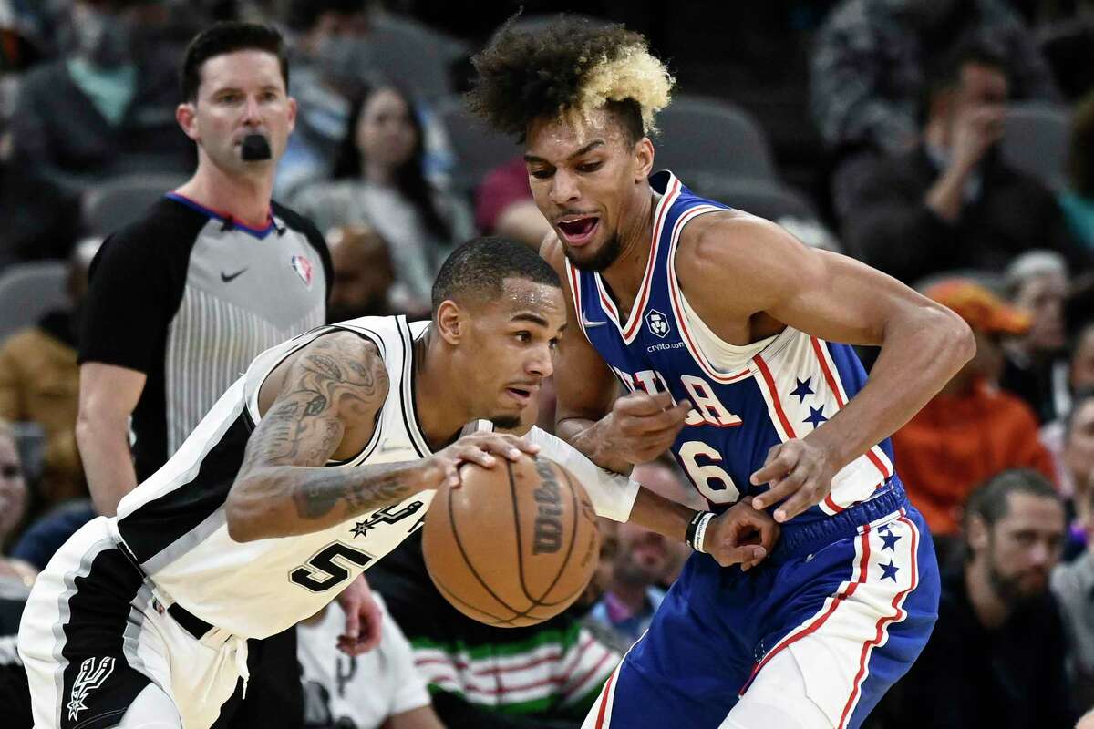 The Spurs’ Dejounte Murray (5) drives against the 76ers’ Charlie Brown Jr. during the first half Sunday, Jan. 23, 2022, in San Antonio. (AP Photo/Darren Abate)