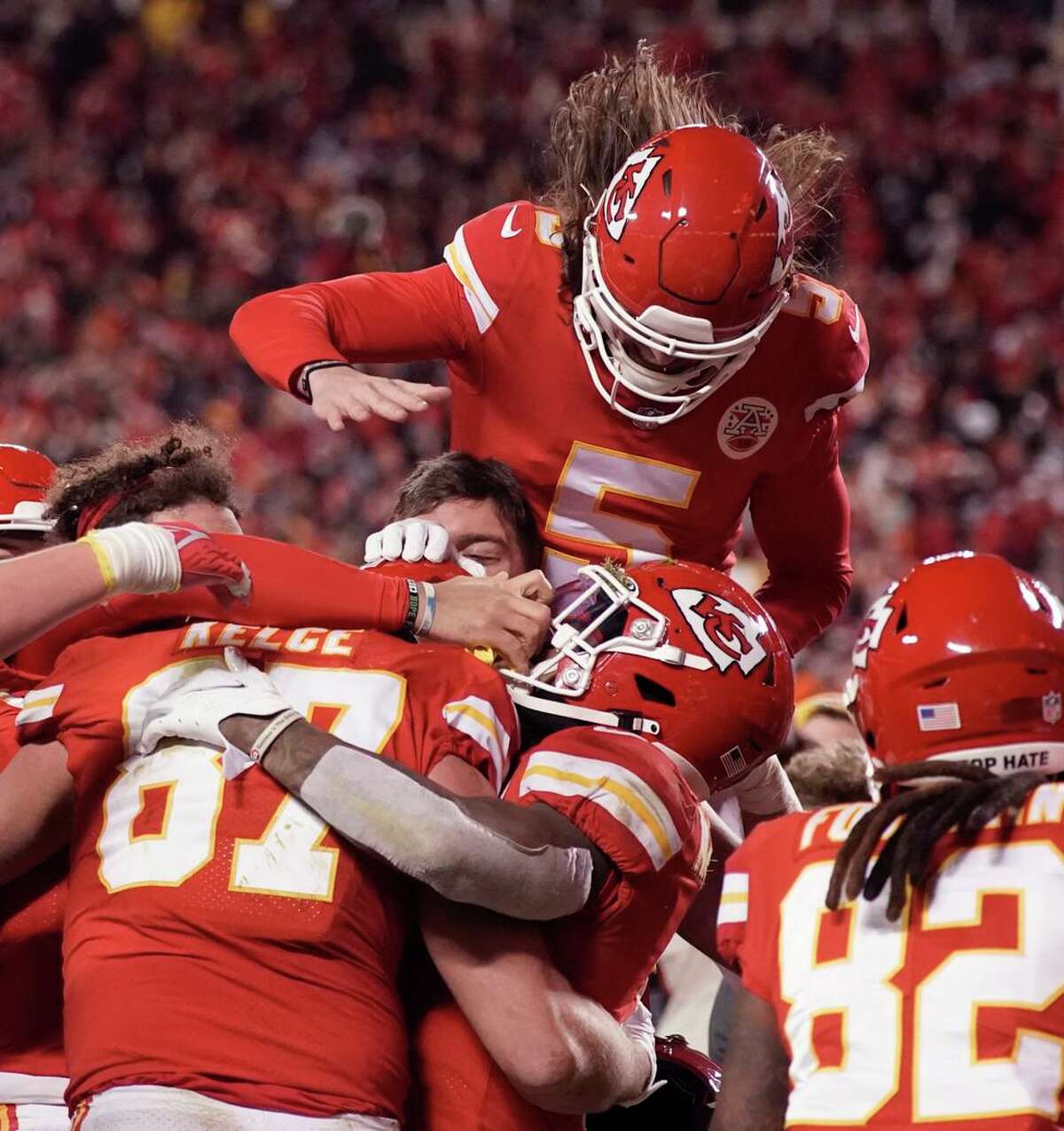 Chiefs tight end Travis Kelce (87) is swarmed by teammates after catching an 8-yard touchdown pass during overtime.