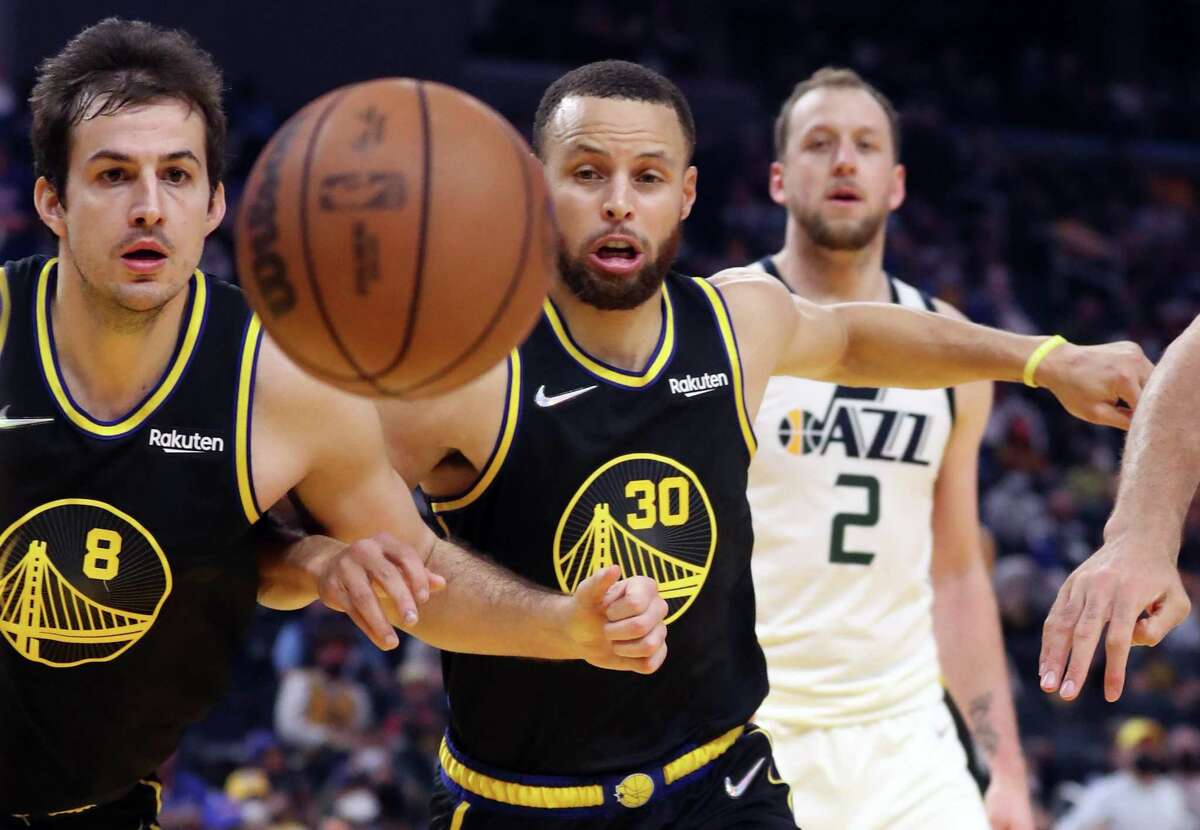 Golden State Warriors' Nemanja Bjelica and Stephen Curry watch a loose ball against Utah Jazz during NBA game in San Francisco, Calif., on Sunday, January 23, 2022.
