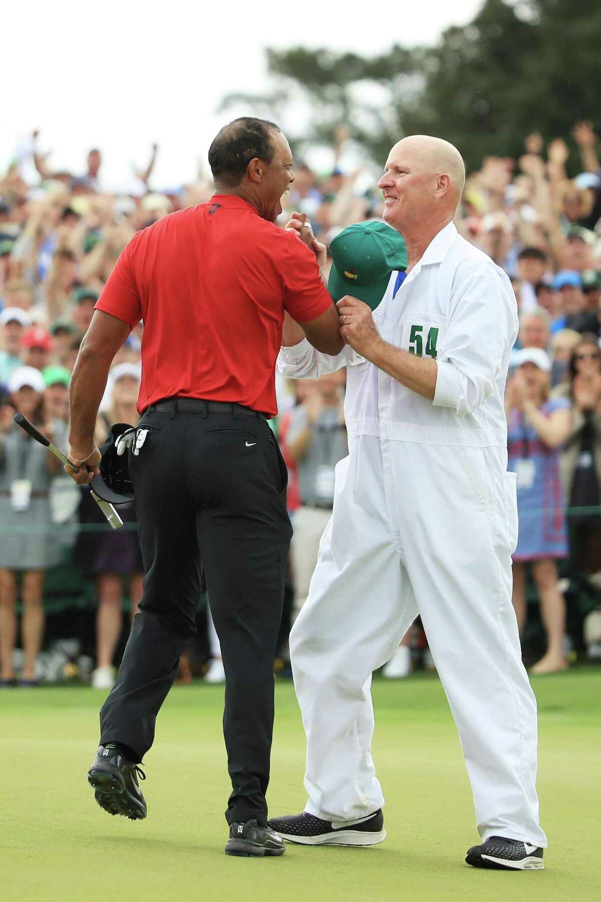 AUGUSTA, GEORGIA - APRIL 14: Tiger Woods (L) of the United States celebrates with caddie Joe LaCava (R) on the 18th green after winning during the final round of the Masters at Augusta National Golf Club on April 14, 2019 in Augusta, Georgia. (Photo by Andrew Redington/Getty Images)