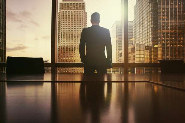 Silhouette of businessman looking out at financial district
