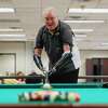 Gaylan Bishop during a game of pool at the City of Conroe Senior Center, Wednesday, Jan. 19, 2022, in Conroe. Bishop lost both his hands and was burned on 40 percent of his body after falling into an electrical transformer while working as an electric distribution manager in North Carolina in 2016.