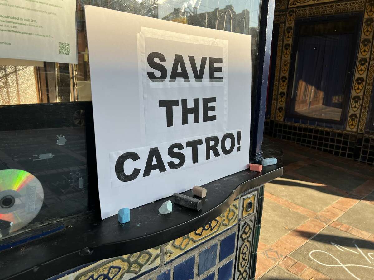 A "Save the Castro!" sign is adhered to the box office window in front of the theater. 