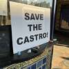 A "Save the Castro!" sign is adhered to the box office window in front of the theater. 
