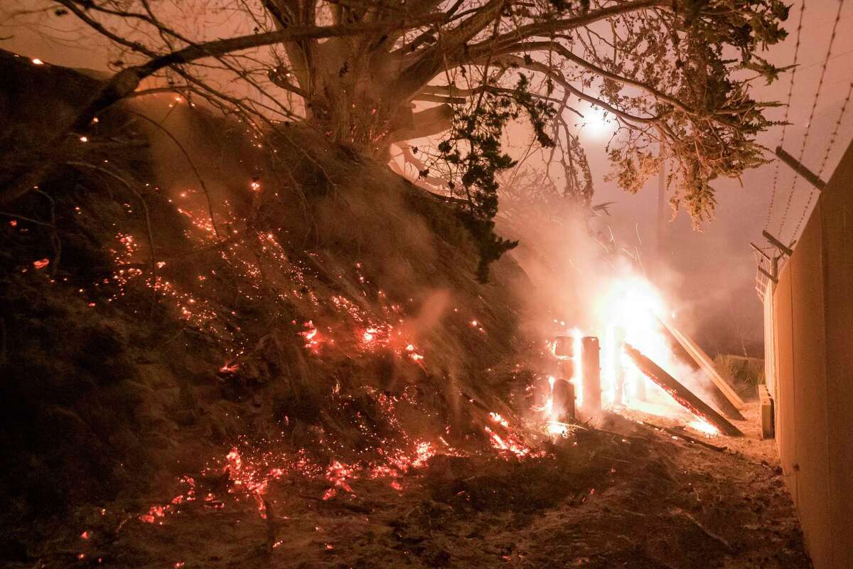 The Colorado Fire burns a fence off Highway 1 in Big Sur on Saturday.