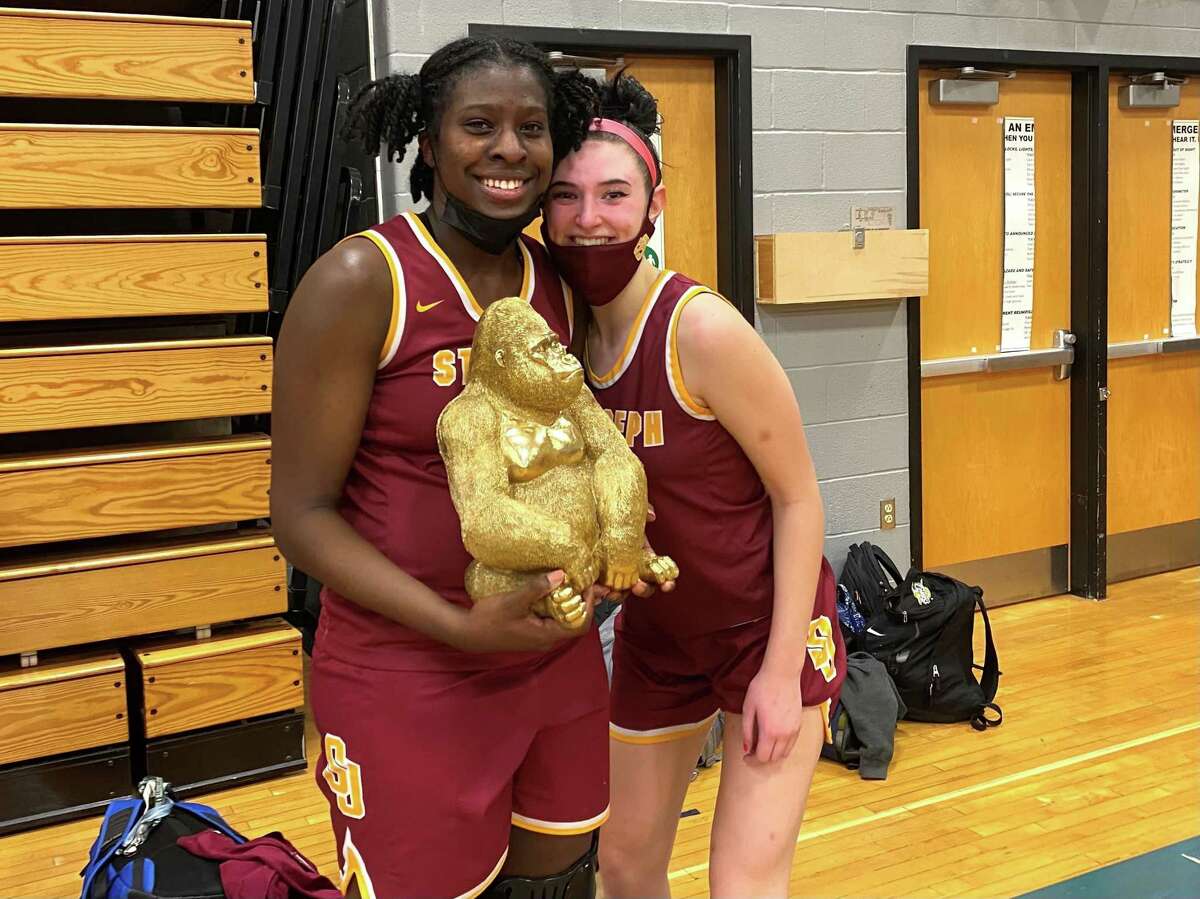 St. Joseph seniors Dennaye Hinds and Kate Rudini pose with the team's gold gorilla which sits on the end of the bench during games. St. Joseph beat Ludlowe 46-42 in Fairfield on Jan. 24, 2022.