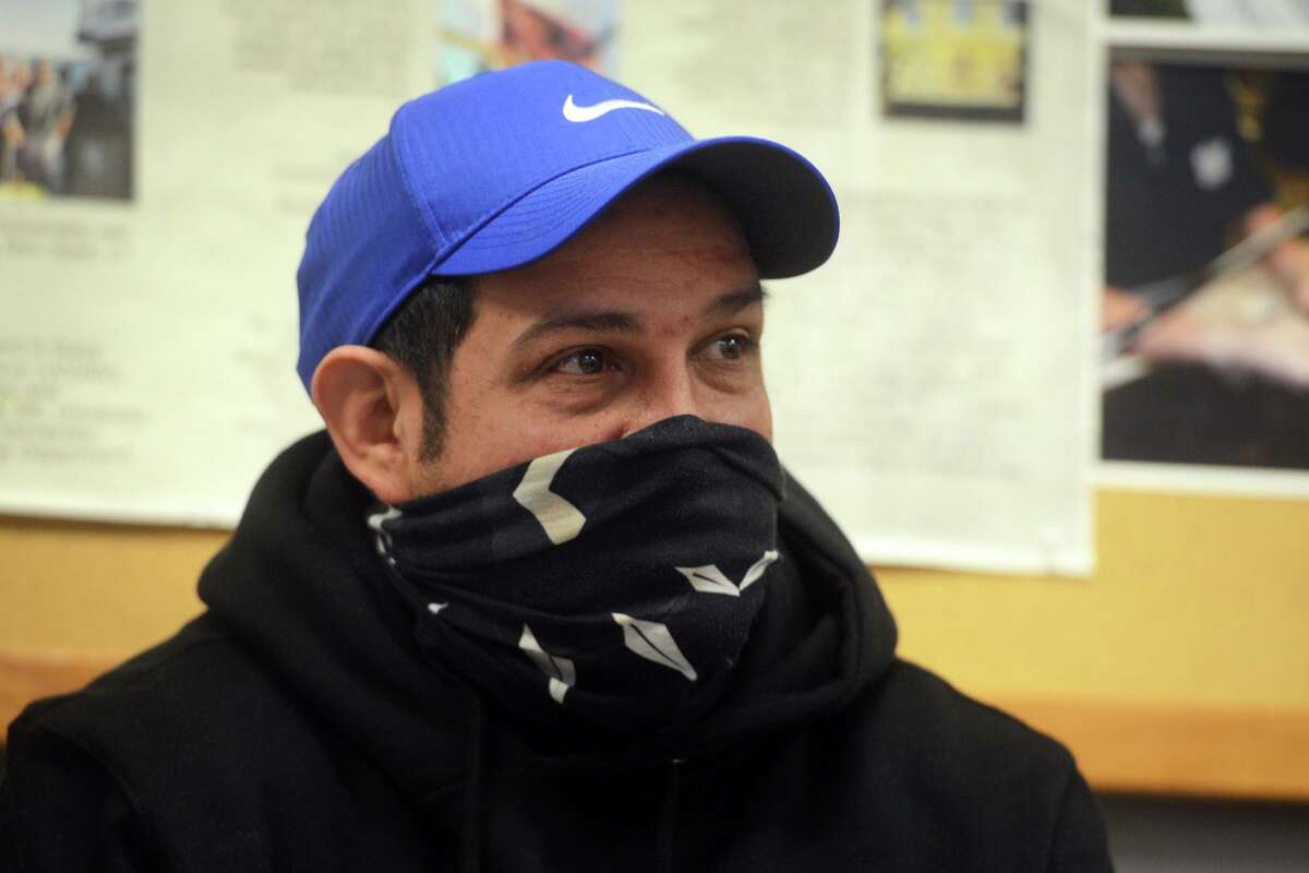 Eddie Santiago looks on while he listens to supports speak on his behalf during a meeting of the Bridgeport Board of Education, in Bridgeport, Conn. Jan. 24, 2022. Dozens of people turned out Monday evening to express their support for Santiago, who was recently relieved of his duties as Harding’s football coach.