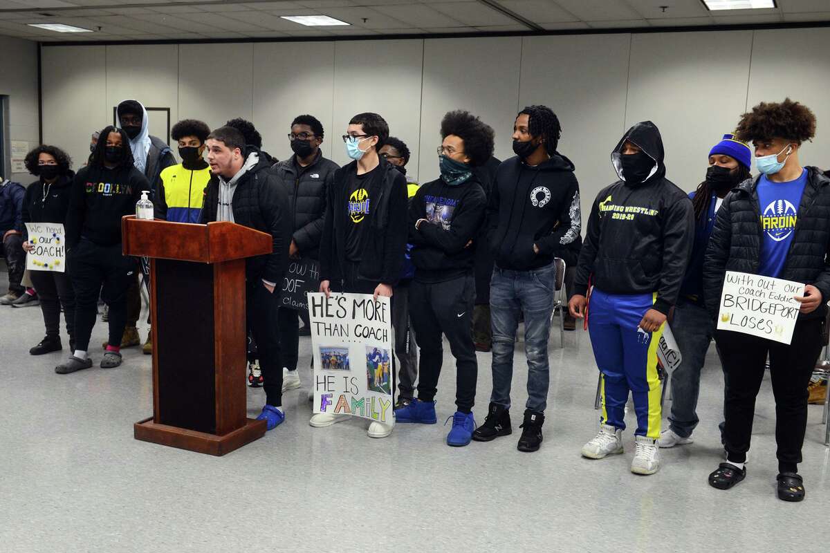 Former football player Kevin Bednarz speaks at the podium with other Harding High School athletes, both former and current, during a meeting of the Bridgeport Board of Education, in Bridgeport, Conn. Jan. 24, 2022. Dozens of people turned out Monday evening to express their support for Harding football and wrestling coach Eddie Santiago.