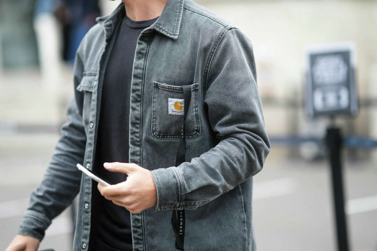 A guest wears a black t-shirt, a gray faded denim shirt from Carhartt, outside LGN Louis Gabriel Nouchi, during Paris Fashion Week - Menswear Spring/Summer 2022, on June 24, 2021 in Paris, France.