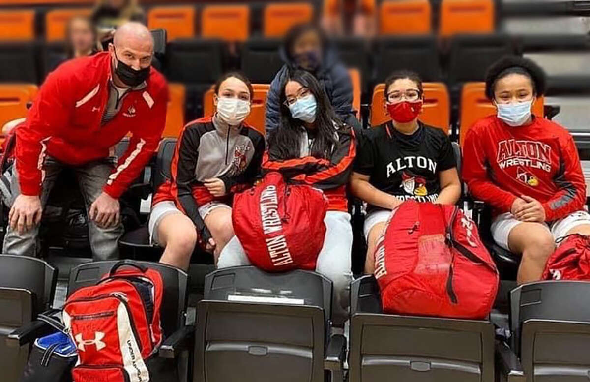 Alton High School's female wrestlers pause at a nine-team event Monday at Waterloo High. From left are AHS assistant coach Wade Lowe, Gabby Mitchell, Phuong Tran, Lola Sumpter and Antonia Phillips.