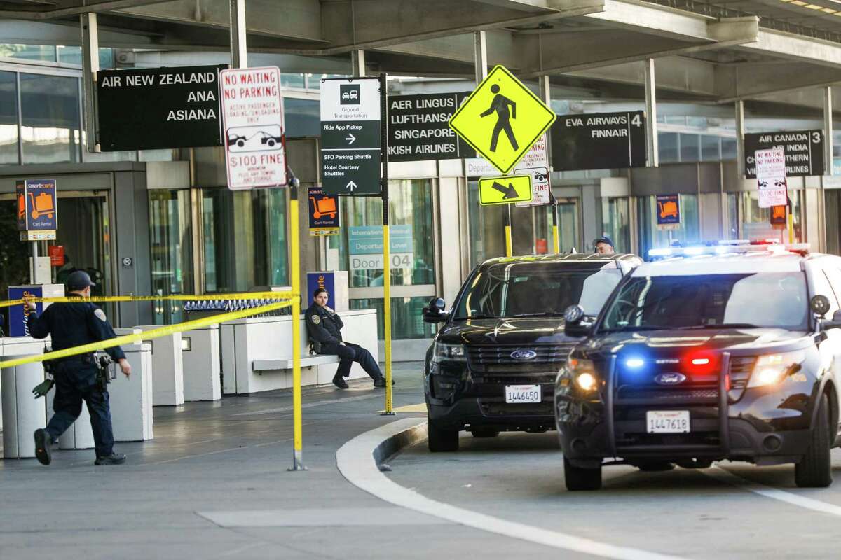 Police officers stand by the International Terminal at San Francisco International Airport after police shot and killed a man allegedly brandishing replica firearms. The man was identified as 37-year-old Nelson Szeto.
