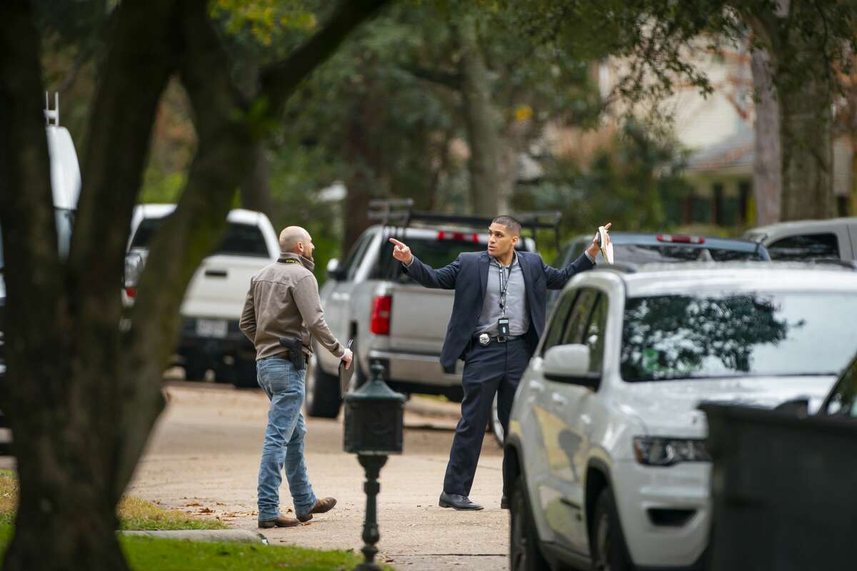 Law enforcement officers work a scene of a possible homicide at a white-columned house along Carolcrest Drive, Tuesday, Jan. 25, 2022, in west Houston. Police confirmed that the case may be related to 26-year-old Ryan Mitchell Smith who is on the run accused by police of stabbing a police K-9.