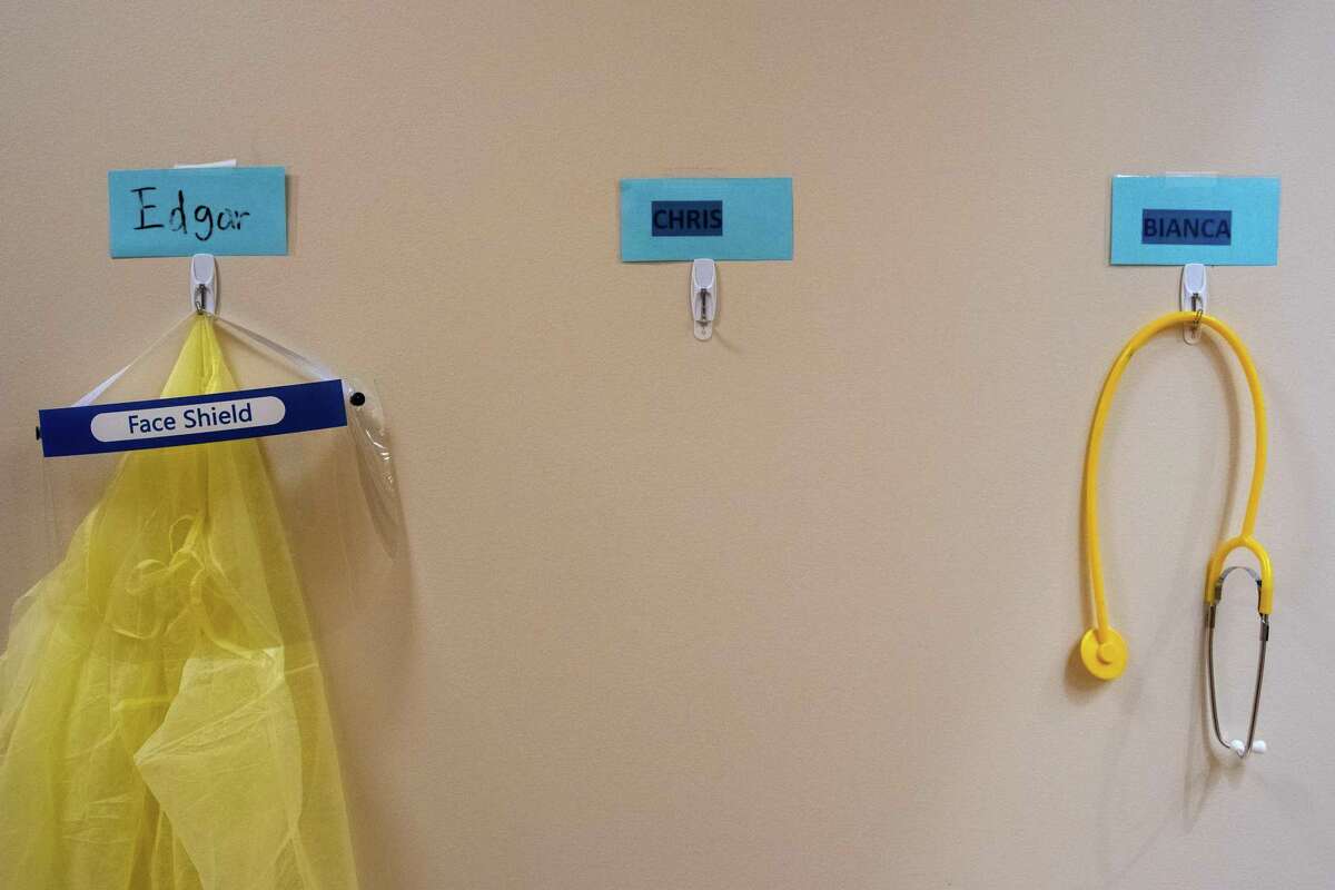 A protective gown, face shield and stethoscope used by healthcare workers hang on a wall at the Petaluma Health Center in Petaluma.
