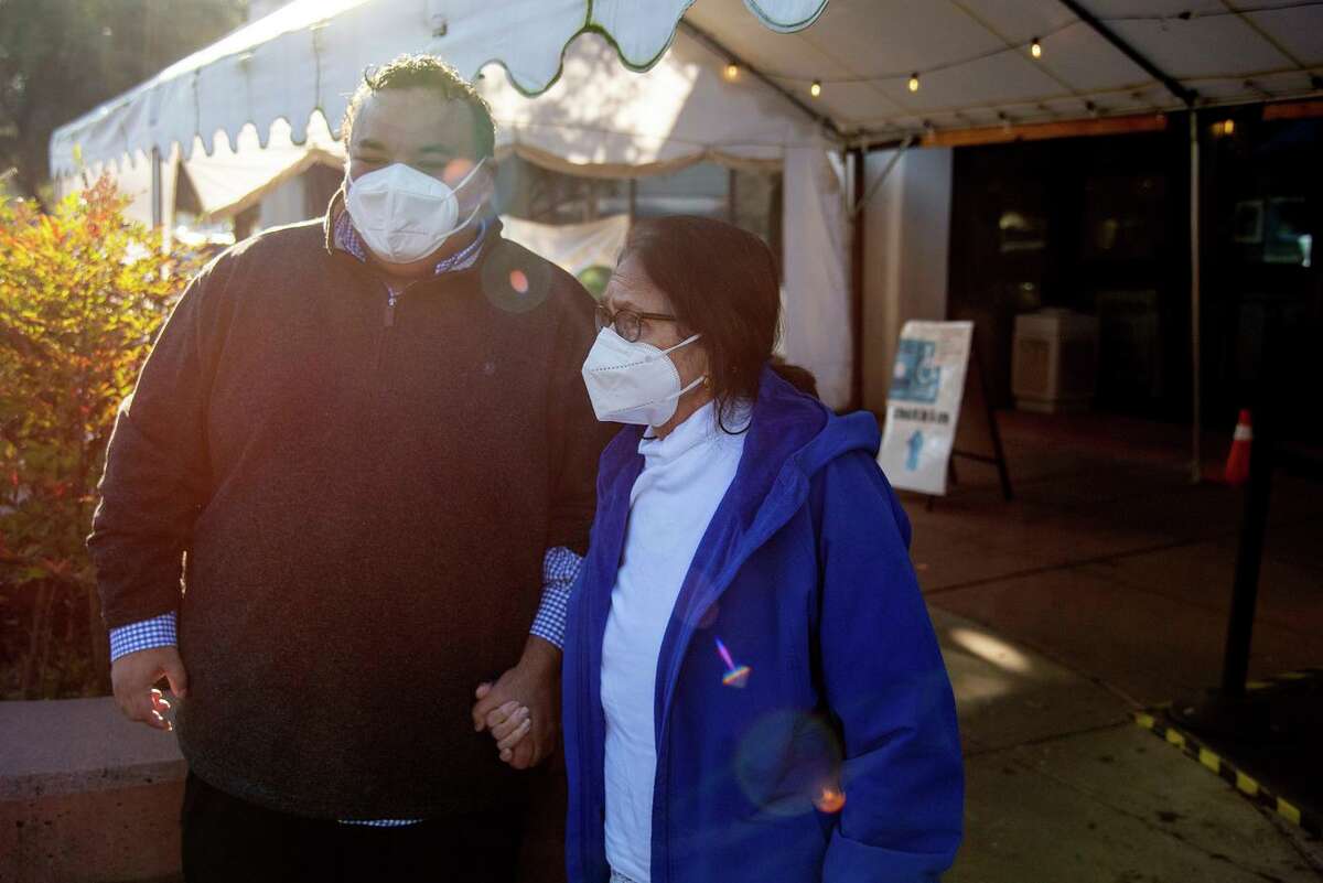 Pedro Toledo, administrative director of the Petaluma Health Center, holds the hand of his mother Simona Toledo at the Petaluma Health Center after she tested positive for the coronavirus.