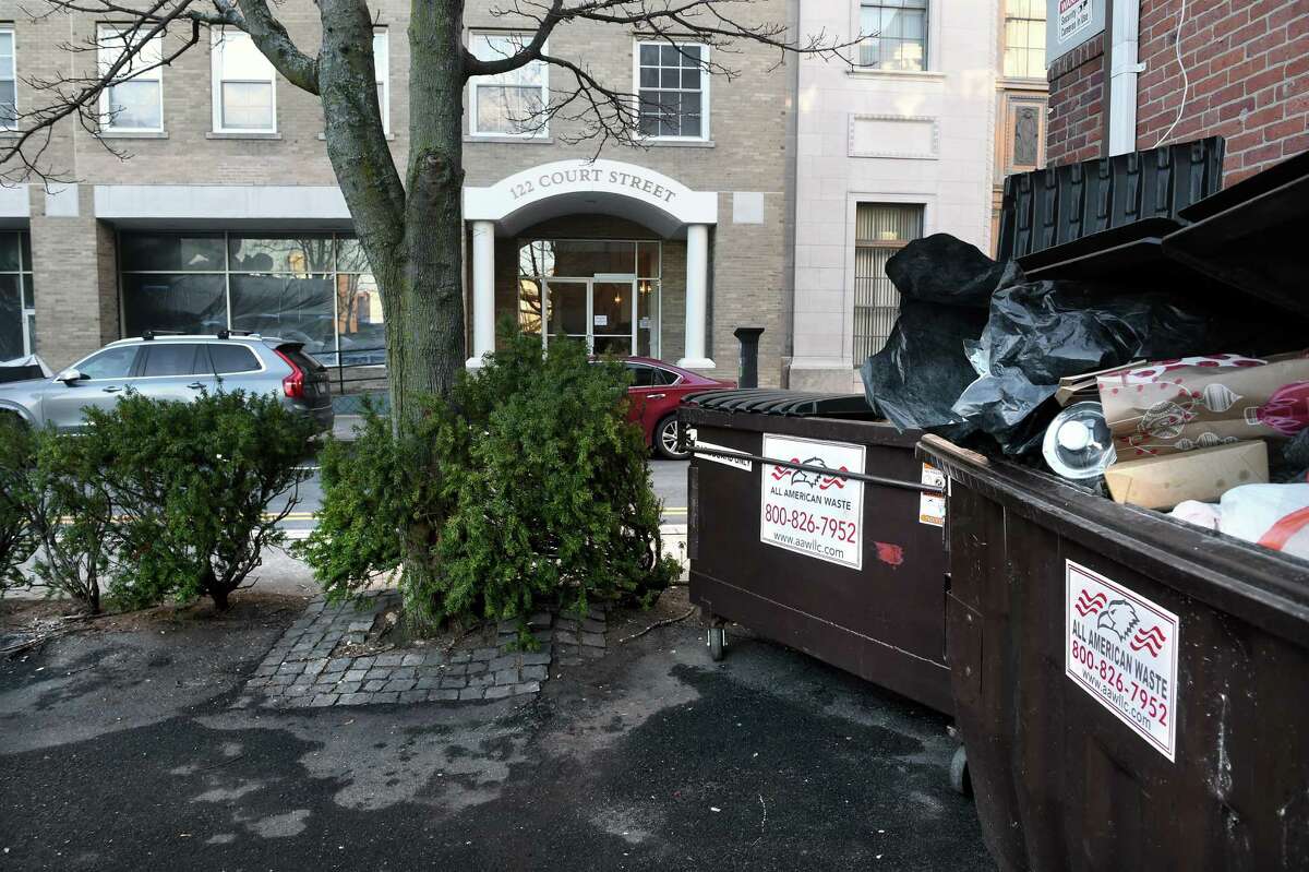 All American Waste dumpsters sit next to a building on Court Street in New Haven on Jan. 25, 2022. The city has fined the company for picking up trash in the area too early, prompting noise complaints.