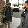 Samm Williams, right, an outreach case manager with Open Door Shelter, checks in on client Daries on the street during an afternoon of canvassing the city homeless population in Norwalk, Conn. on Tuesday, January 25, 2021.