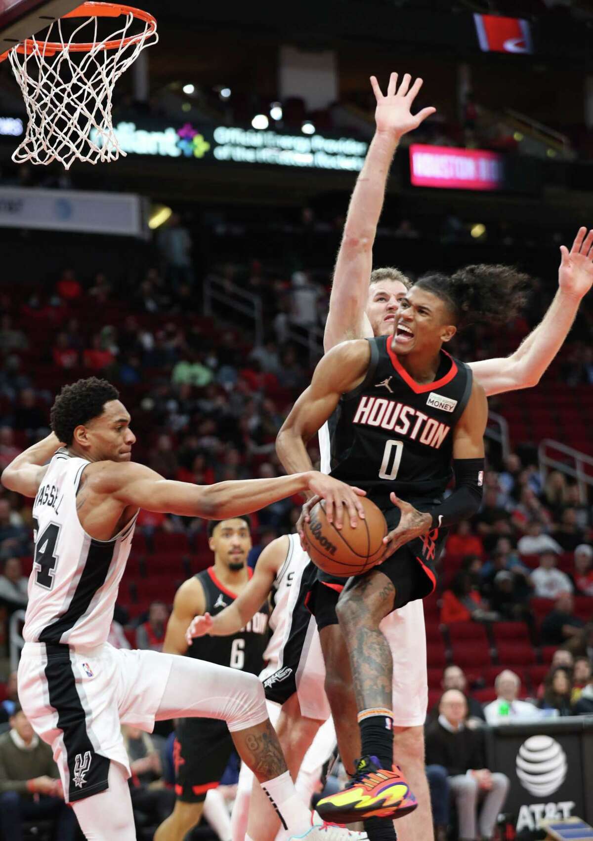 Houston Rockets guard Jalen Green (0) drives to the basket while San Antonio Spurs guard Devin Vassell (24) and center Jakob Poeltl (25) defend during the second quarter of an NBA game Tuesday, Jan. 25, 2022, at the Toyota Center in Houston.