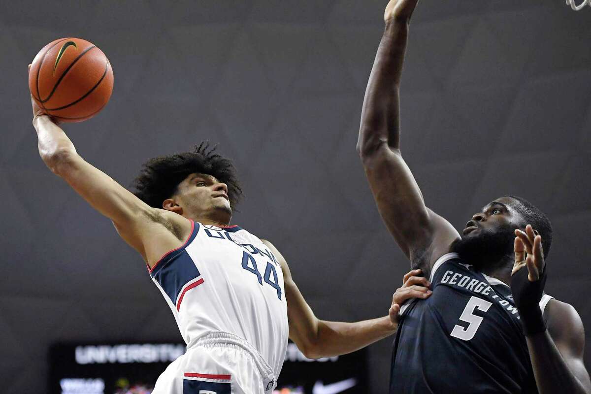 Connecticut's Andre Jackson winds up for a dunk as Georgetown's Timothy Ighoefe (5) defends in the first half of an NCAA college basketball game, Tuesday, Jan. 25, 2022, in Storrs, Conn. (AP Photo/Jessica Hill)