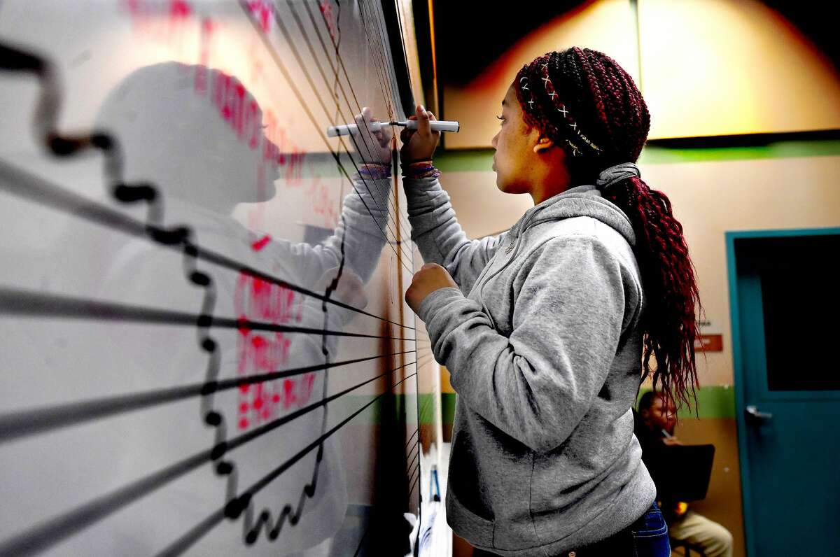 Kristija Curtis works on writing out notes and scales in Joshua Robinson's band class at Pietzsch-MacArthur Pre-K - 8 Center. The newly expanded campus is now offering extracurriculars that it hasn't in years past, including band, theater and e-sports. Photo made Tuesday, January 25, 2022 Kim Brent/The Enterprise