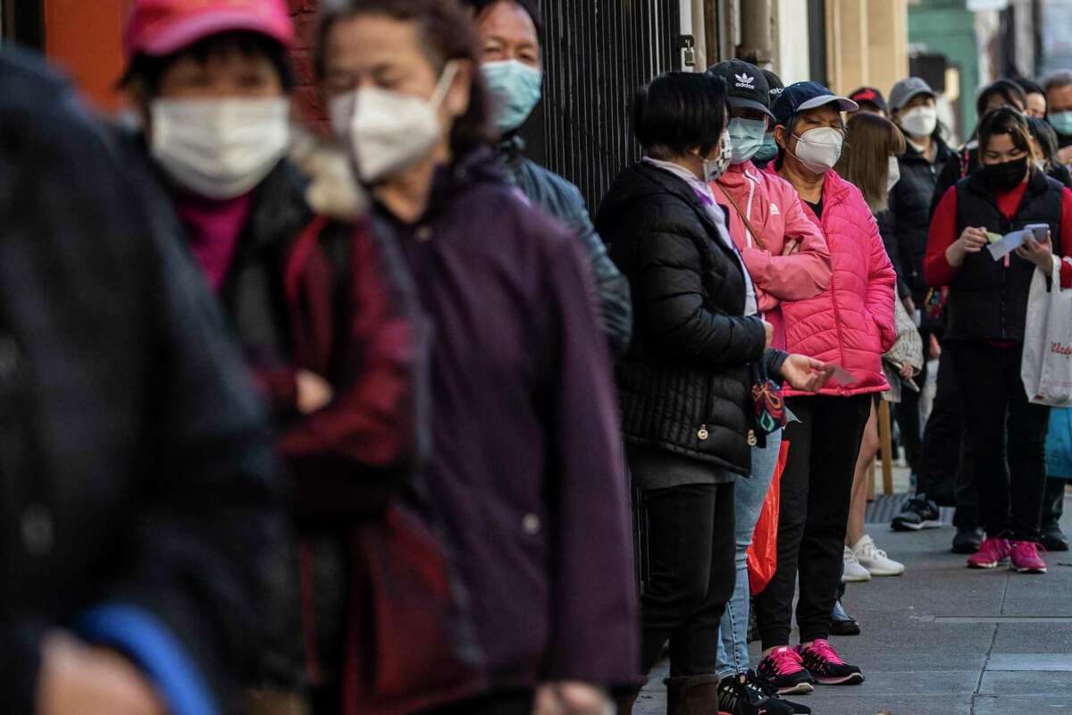 居民们在唐人街社区发展中心排队领取冠状病毒检测包。