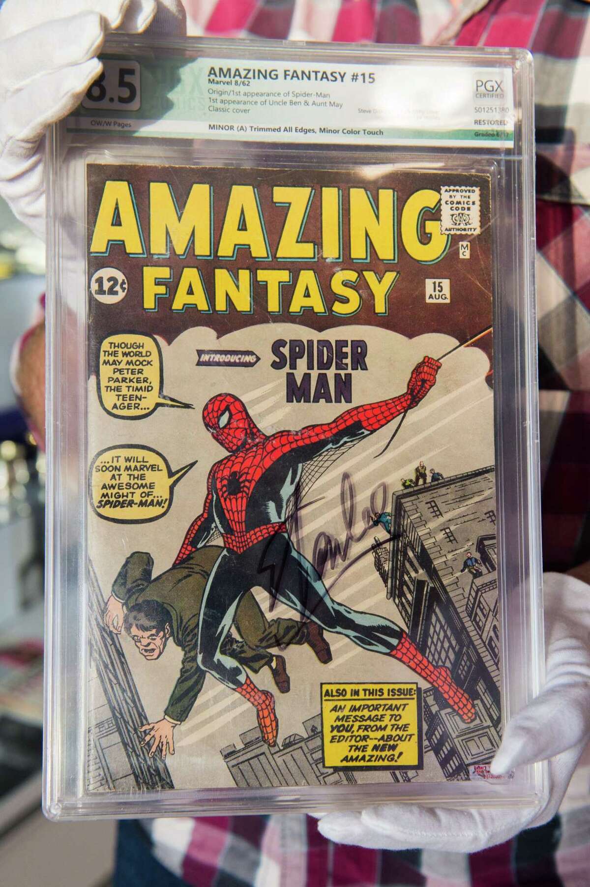 A Julien's Auctions appraisal consultant displays the "Amazing Fantasy #15" comic book autographed by Stan Lee at Julien's Auction House in Beverly Hills, California, on November 13, 2018. "Amazing Fantasy #15" features the very first appearance of Marvel's Spider-Man.