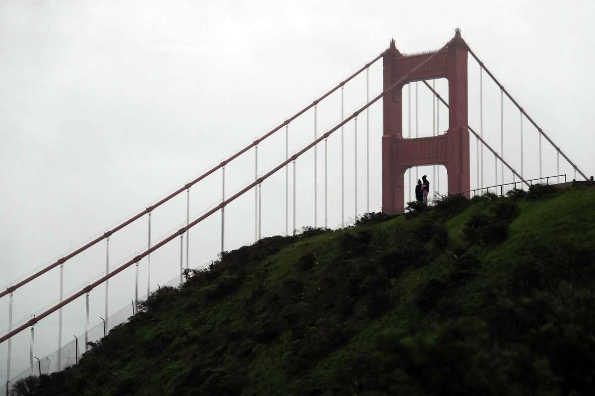 Tourists visit the Marin Headlands overlooking the Golden Gate Bridge in Sausalito, Calif. Hopes for a wet end to a dry January were dashed after a storm system tracking south from the Gulf of Alaska shifted east.