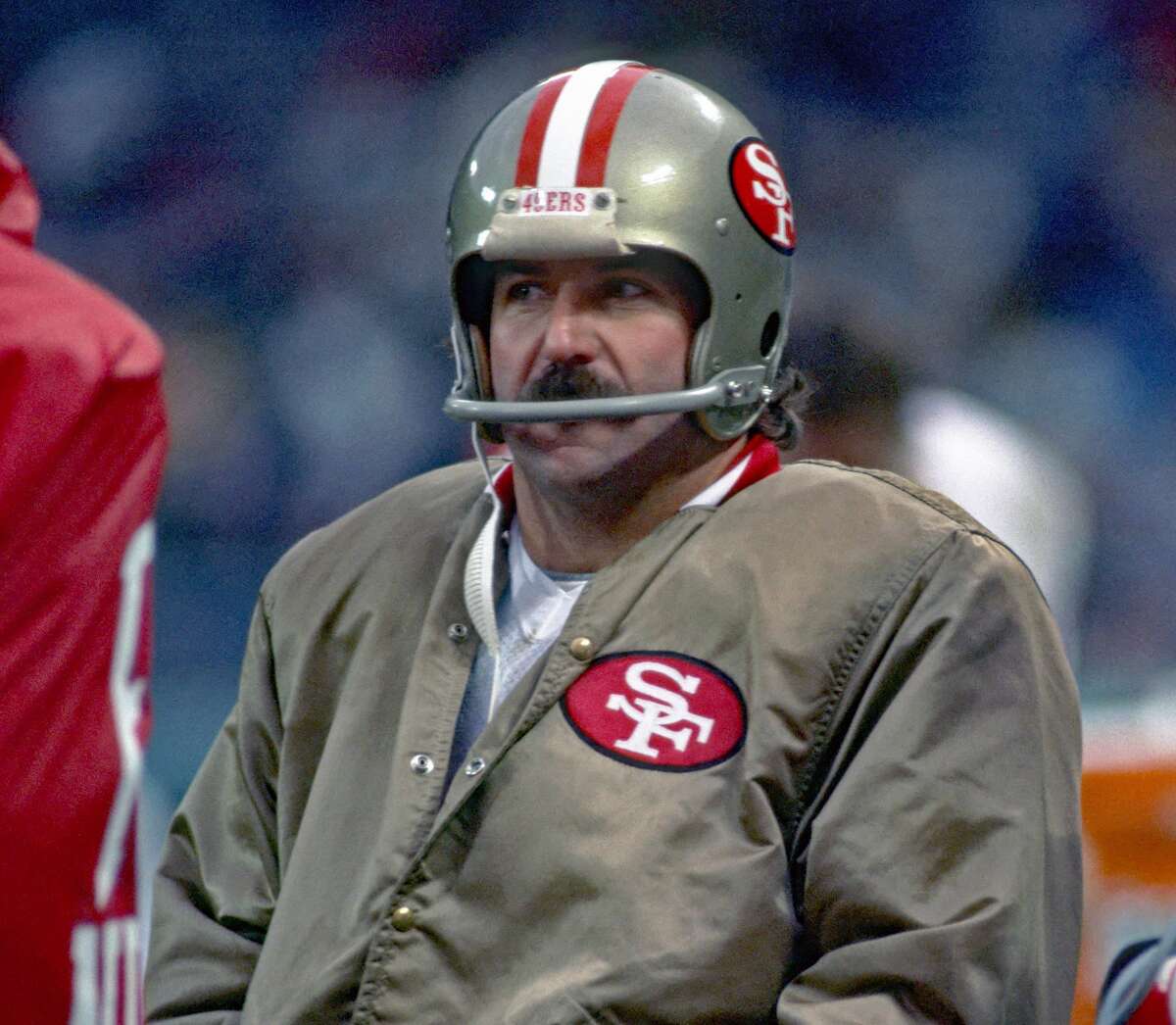 San Francisco 49ers kicker Ray Wersching, wearing the team jacket that inspired Chalk Line's gold satin Niners jackets, looks on from the sideline during a 1984 game against the Cleveland Browns in Cleveland, Ohio.