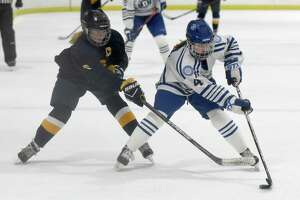 Darien's Keira Austen (4) and Simsbury's Mackenzie Chapman (6) battle for the puck during a girls ice hockey game at the Darien Ice House on Wednesday, Jan. 26, 2022.