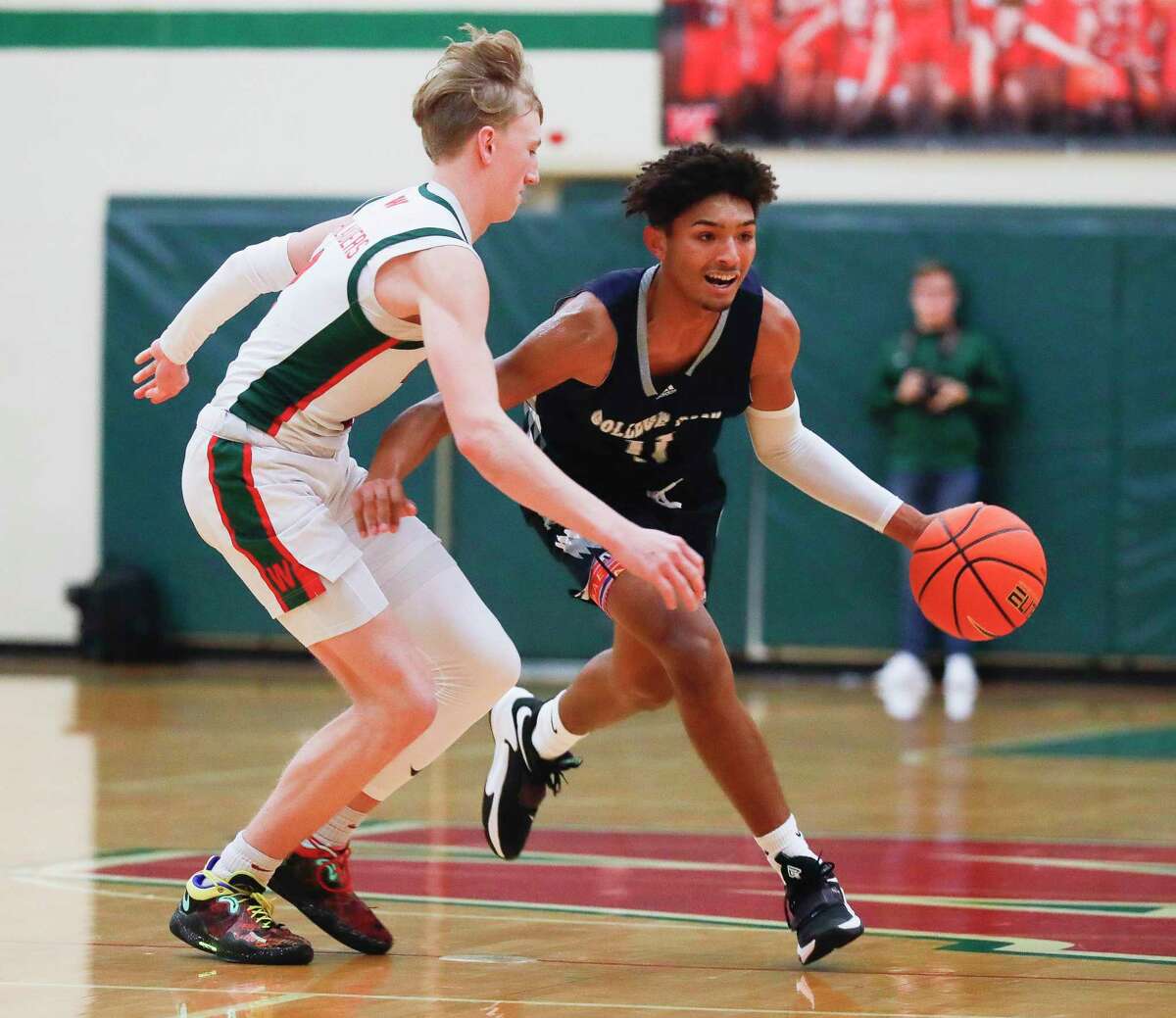 College Park guard Ty Buckmon (11) drives past The Woodlands guard Shey Eberwein (2) during the first quarter of a high school basketball game at The Woodlands High School, Wednesday, Jan. 26, 2022, in The Woodlands.