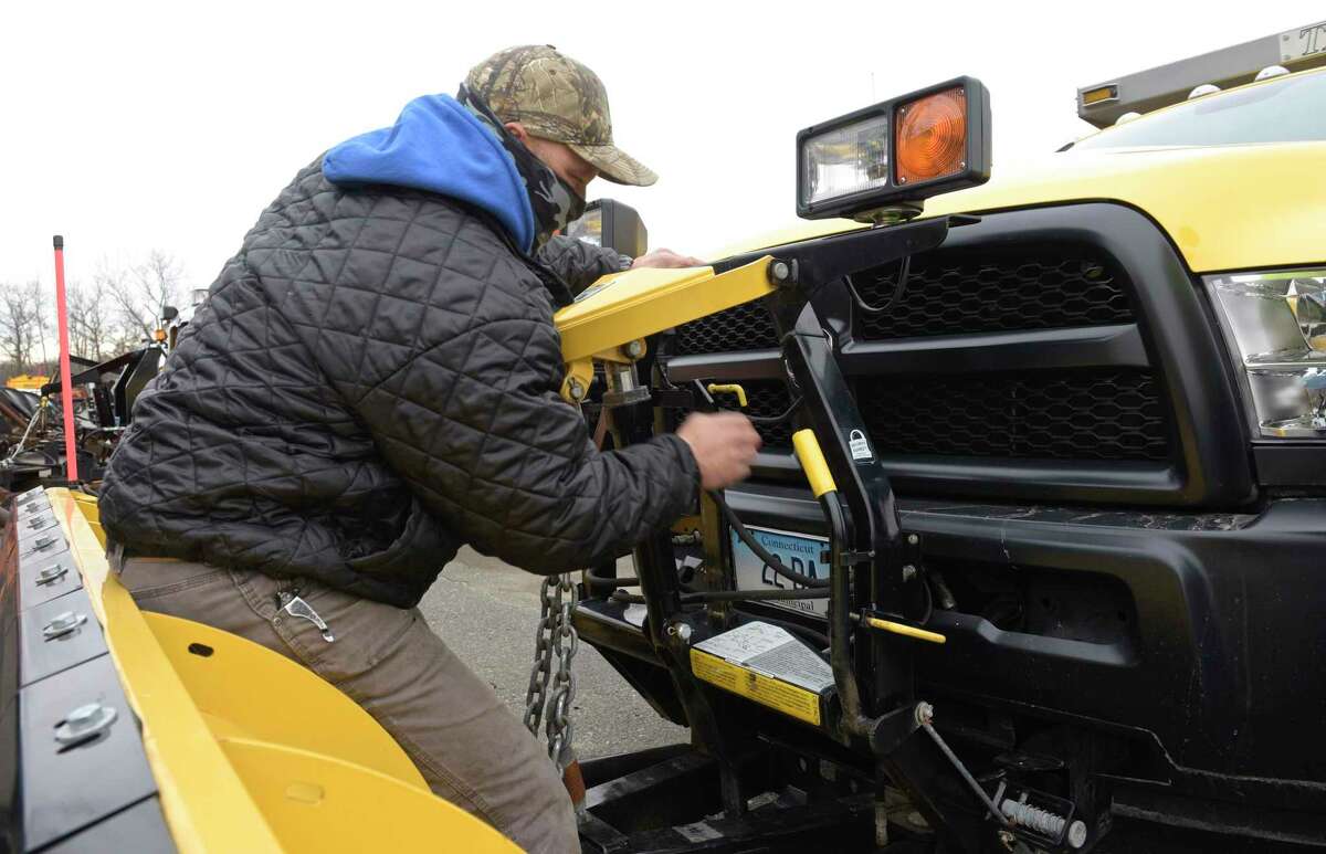 John Pararino installs a snowplow onto a truck at the Danbury in December, 2020, ahead of a forecast nor'easter.