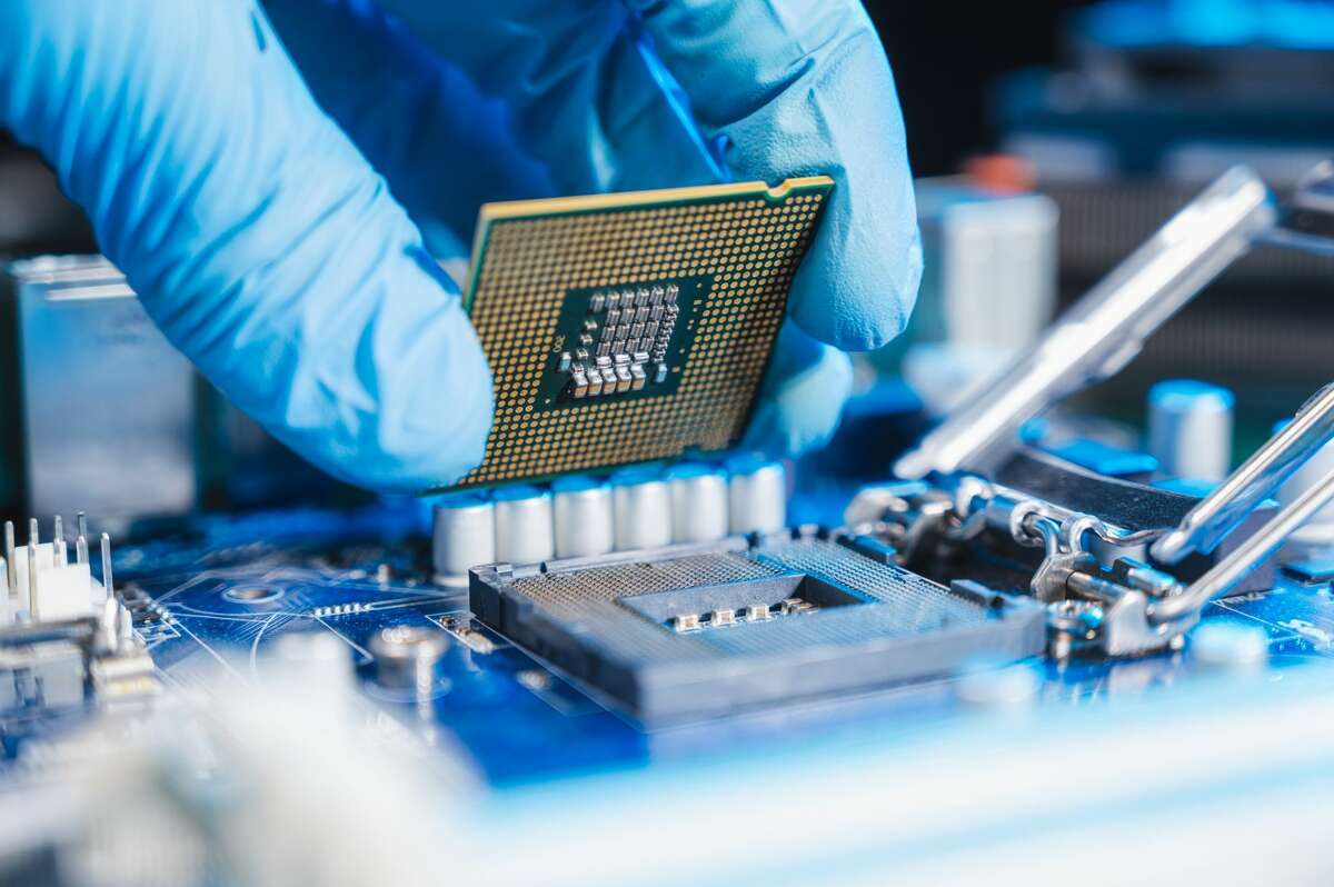 An image of a semiconductor computer chip being inserted into a product. 