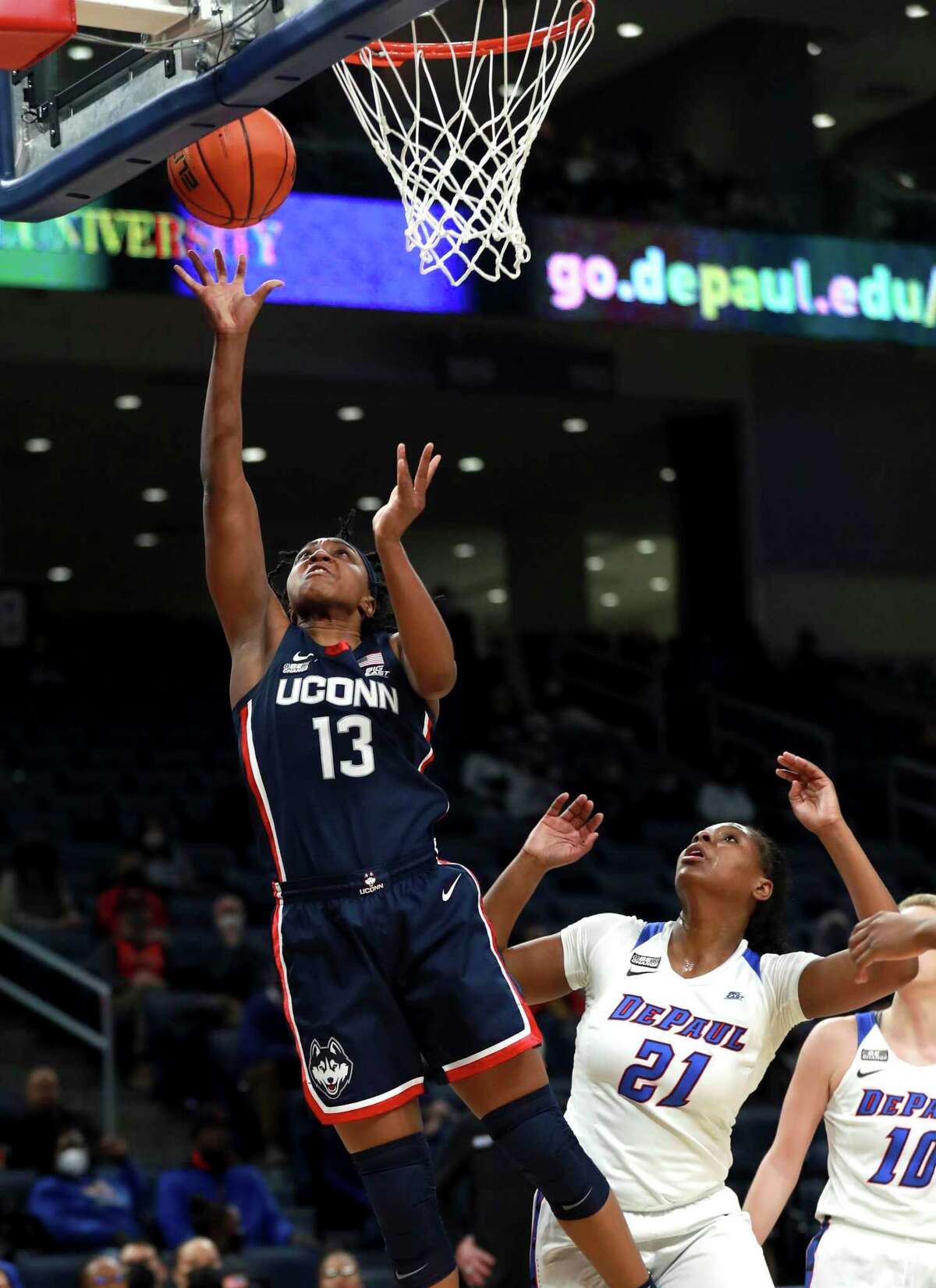 Connecticut guard Christyn Williams (13) drives to the hoop past DePaul guard Darrione Rogers (21) in the first half of an NCAA college basketball game at Wintrust Arena in Chicago on Wednesday, Jan. 26, 2022. (Chris Sweda/Chicago Tribune via AP)