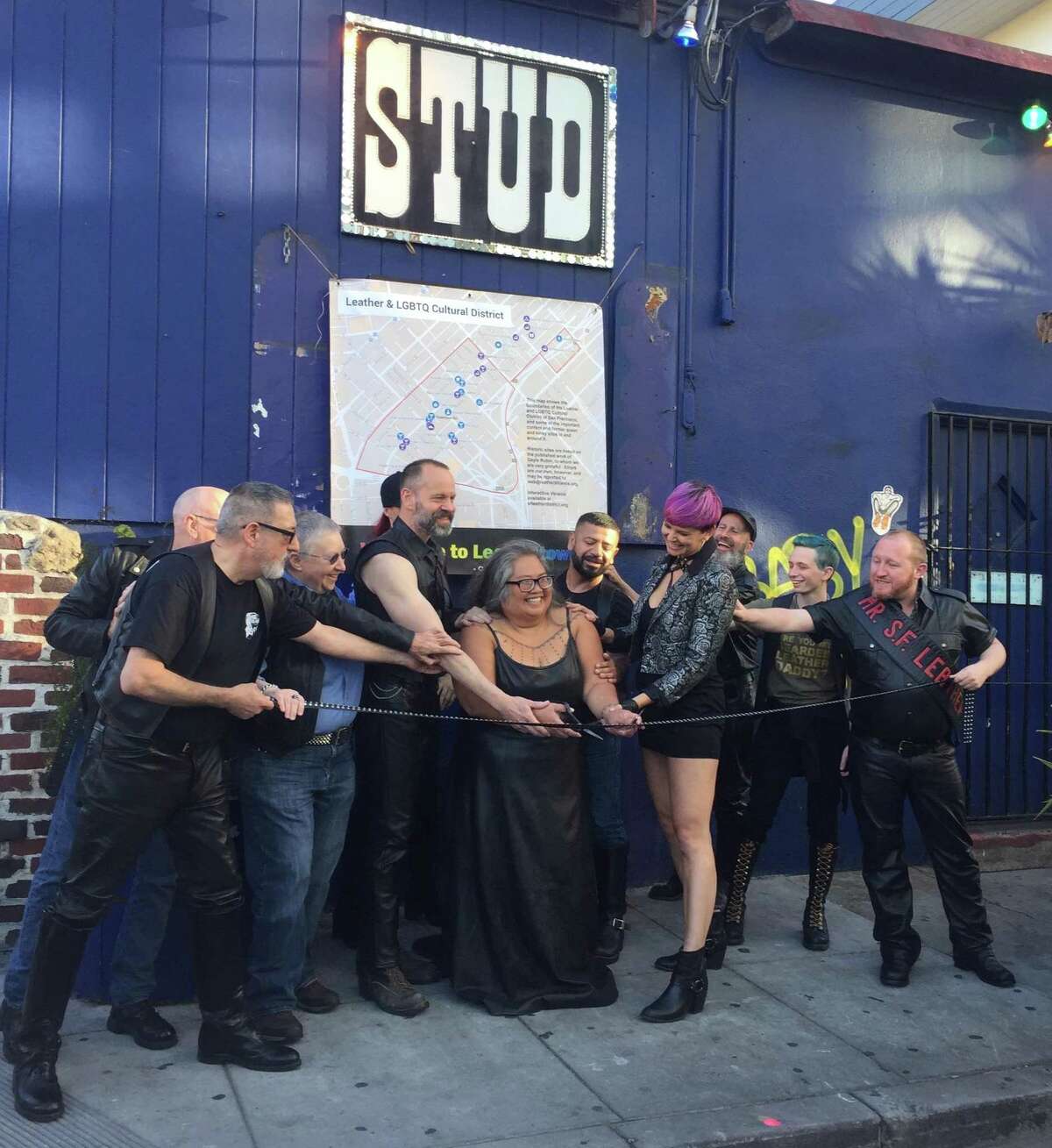Rachele Sullivan (with scissors) at the opening of the Leather & LGBTQ Historical District in 2018.