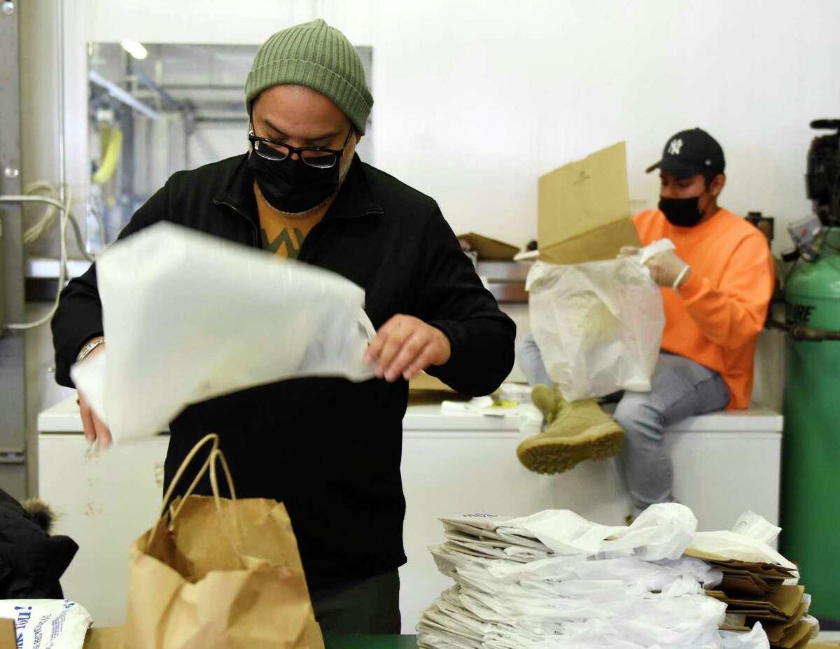 Employees Elvis Ruiz, left, and Albert Calixto work at Neighbor to Neighbor food pantry's temporary location at 1 Horseneck Lane in Greenwich, Conn. Thursday, Jan. 27, 2022. Construction of the new facility at Christ Church has been delayed due to supply chain issues.