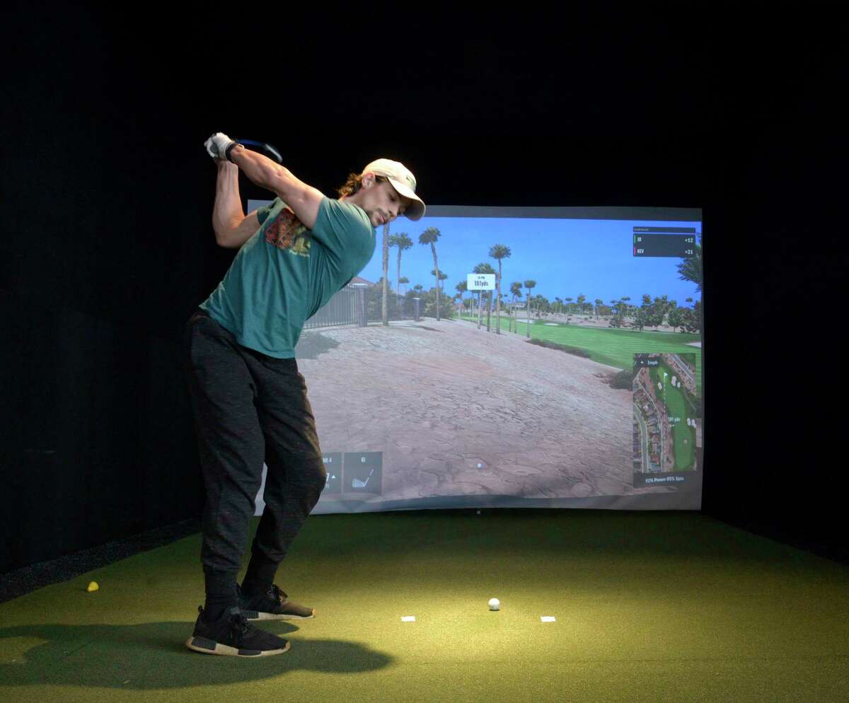 Joe Bisordi, of Bethel, plays a round of golf at Golf Lounge 18, a mix of a golf simulator, restaurant and bar, which has opened in the Danbury Fair mall in Danbury, Conn. Wednesday, January 26, 2022.