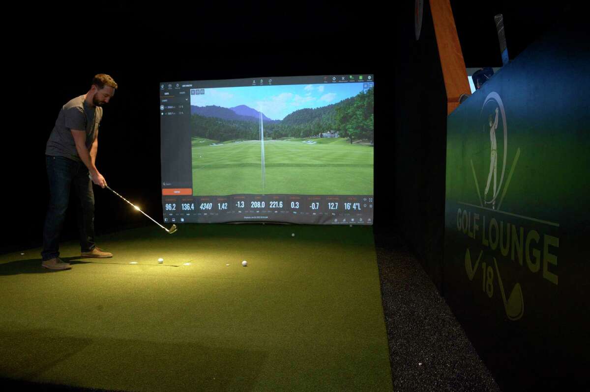 Bill Thode of Ridgefield sets a shot during a simulation at Golf Lounge 18, a golf simulator, a mix of restaurant and bar that opened Wednesday, January 26, 2022 at Danbury Fair Mall in Danbury, Conn.