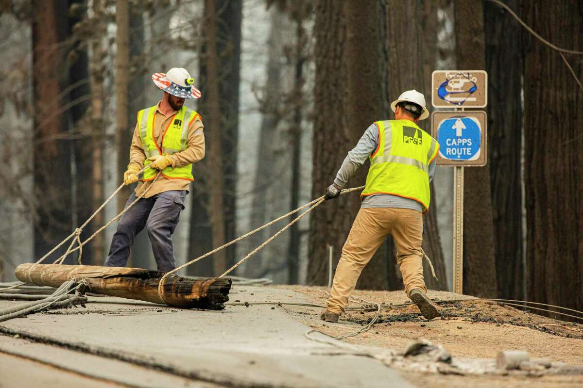 A PG&E crew removes trees and power lines from Sciaroni Road in Grizzly Flats (El Dorado County) on Aug. 18 in the aftermath of the Caldor Fire.