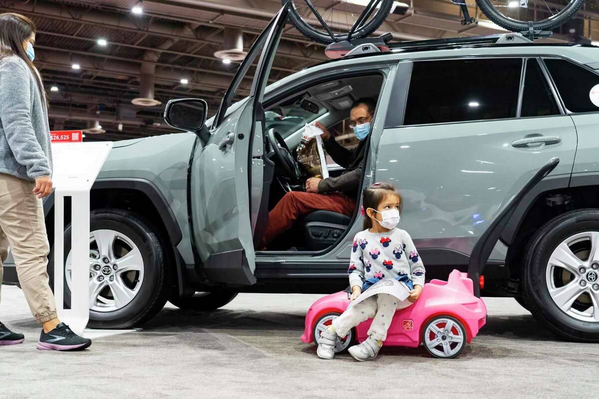 Three-year-old Sophie Camarillo waits in her own car as her parents, Juan and Romi, look at a RAV4 at the 2022 combined Houston Boat Show and Houston Auto Show, Thursday, Jan. 27, 2022, at NRG Center. The family has just started the process of buying a new car, and they wanted to come browse in an environment where they would not be hounded by salespeople, said Juan Camarillo. Steep prices and lack of inventory are not keeping the family out of the car market. “If you need it, you need it. If it’s time to replace it, it’s time,” said Camarillo.
