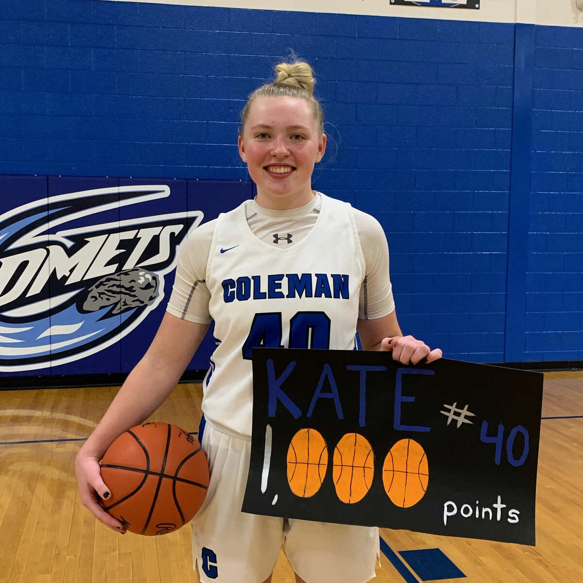 Coleman's Katelyn Pnacek poses with a commemorative sign after reaching the 1,000-point mark for her career in Thursday's win over Breckenridge, Jan. 27, 2022. Pnacek scored 28 points on Saturday to become the all-time leading scorers in school history.