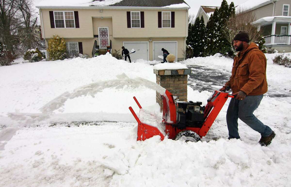 Nick Allen uses his snowblower to remove snow in front of a home along Lincoln Avenue in Bridgeport, Conn., on Tuesday Feb. 2, 2020. The first major storm of 2022 is expected this weekend, with more than a foot of snow expected in parts of the state.