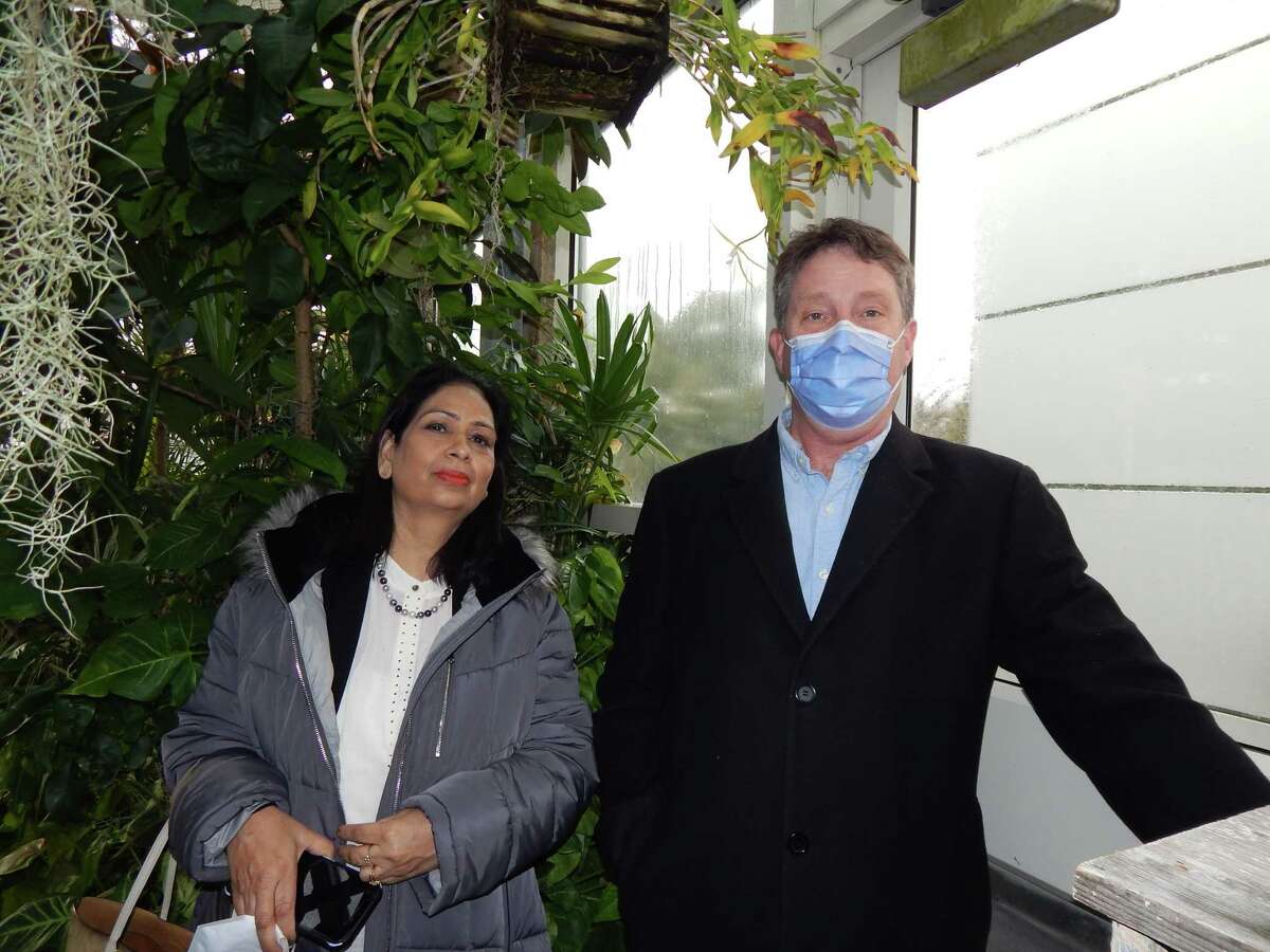 Dr. Promila Pathak (left), chair of the Botany Department at Panjab University in Chandigarh, India, and Dr. Lawrence Zettler, a biology professor at Illinois College, stand Thursday near a ghost orchid (overhead) in the IC greenhouse atop Parker Science Building on the IC campus.
