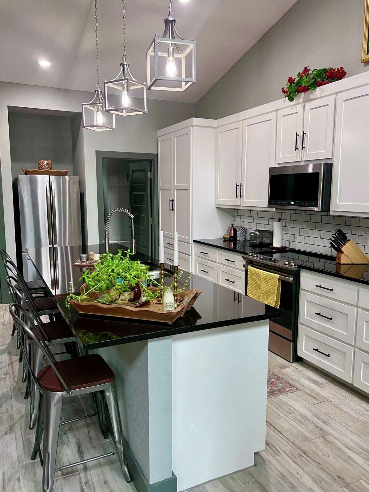 The home's contemporary design touches include the ceramic tile flooring that looks like wood planks, white subway tile in the kitchen and black granite countertops throughout.