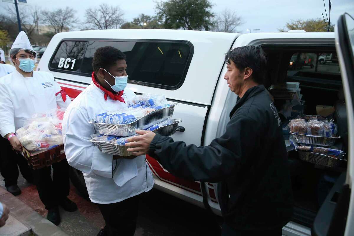 San Antonio Fire Department Engineer David Gibson picks up Kiolbassa sausage tacos and Tastykake honey buns during the 44th annual Cowboy Breakfast at St. Philip?•s College, Friday, Jan. 28, 2022. The school?•s culinary students also helped with the cooking. It was a toned-down private event for San Antonio first responders due to COVID-19 concerns.