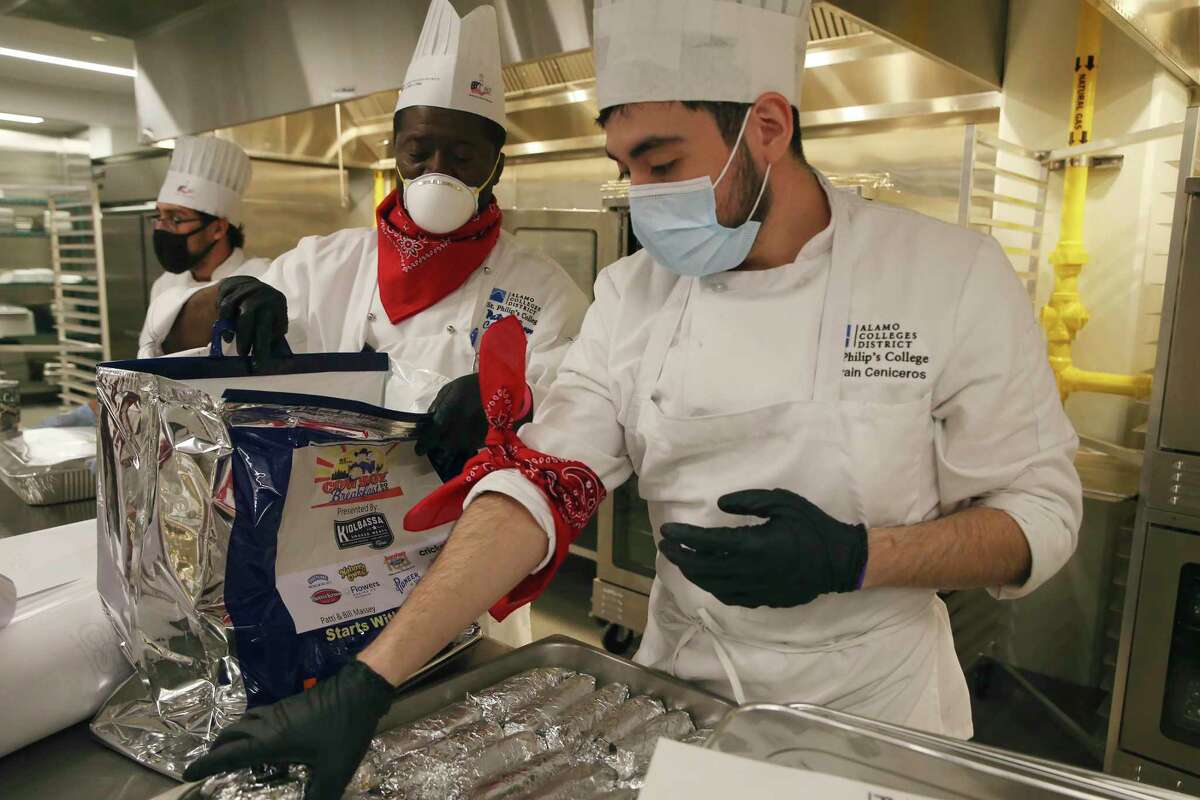 Chef Instructor Patrick Brown, left, and student, Adrian Ceniceros pack Kiolbassa sausage tacos for first responders during the 44th annual Cowboy Breakfast at St. Philip?•s College, Friday, Jan. 28, 2022. The school?•s culinary students also helped with the cooking. It was a toned-down private event due to COVID-19 concerns.