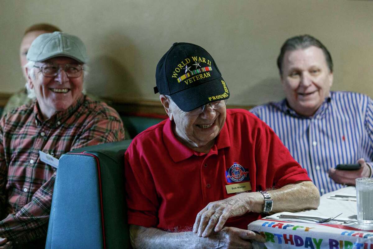 Bob Warren, center, celebrates his upcoming 101st birthday with Charlie O’Connors, left, his son-in-law Tommy Marlin, right, and other friends and family during a veterans’ breakfast at a Jim’s Restaurant in Helotes on Friday morning. The World War II veteran will turn 101 on Tuesday.