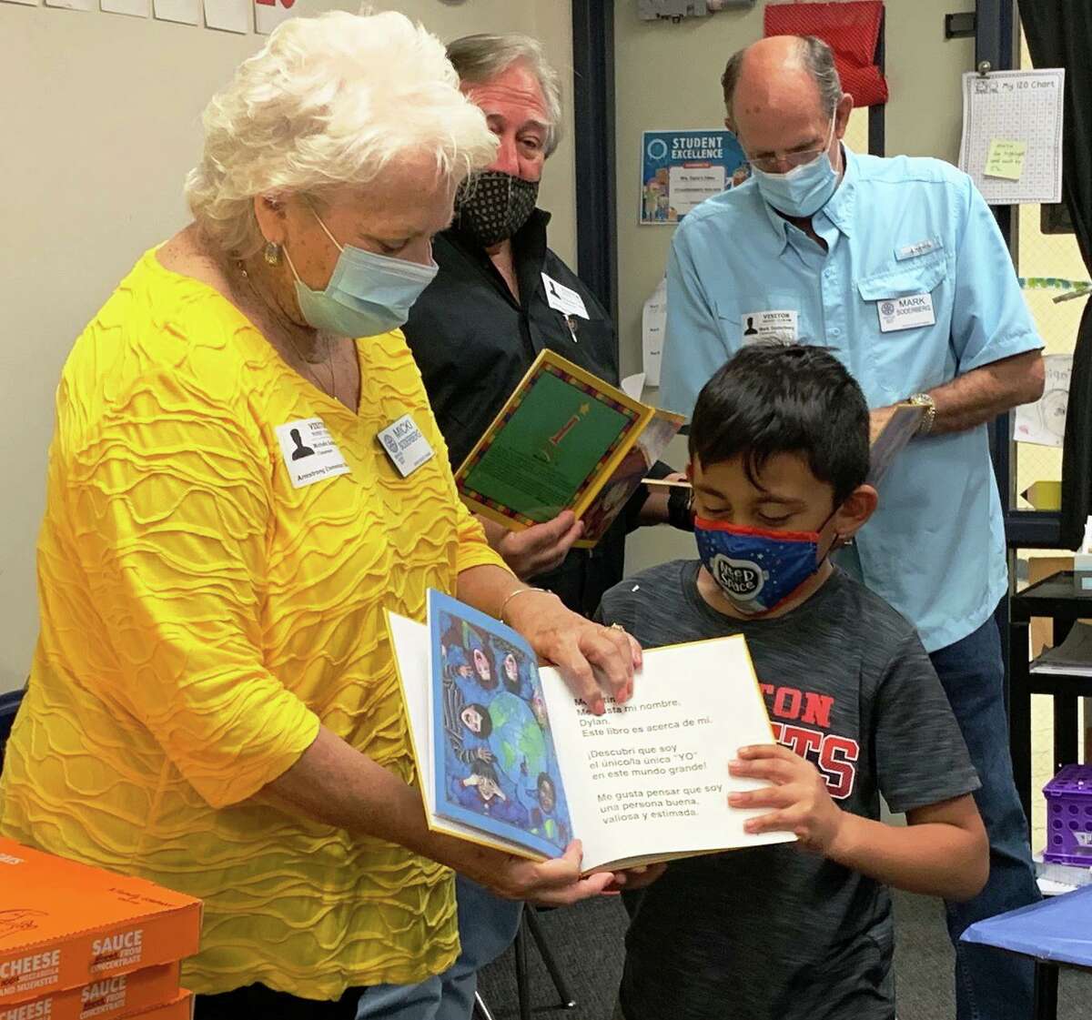 Conroe Rotarian Micki Soderberg is pictured with Lamar Casparis and Mark Soderberg presenting an "I Like Me" book to a Conroe ISD first grader.